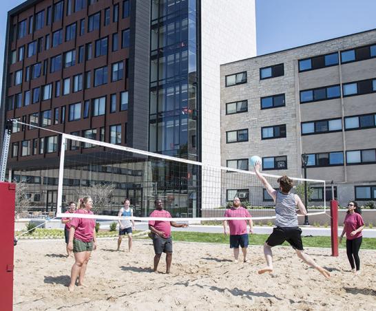 Students play volleyball outside The Tower.